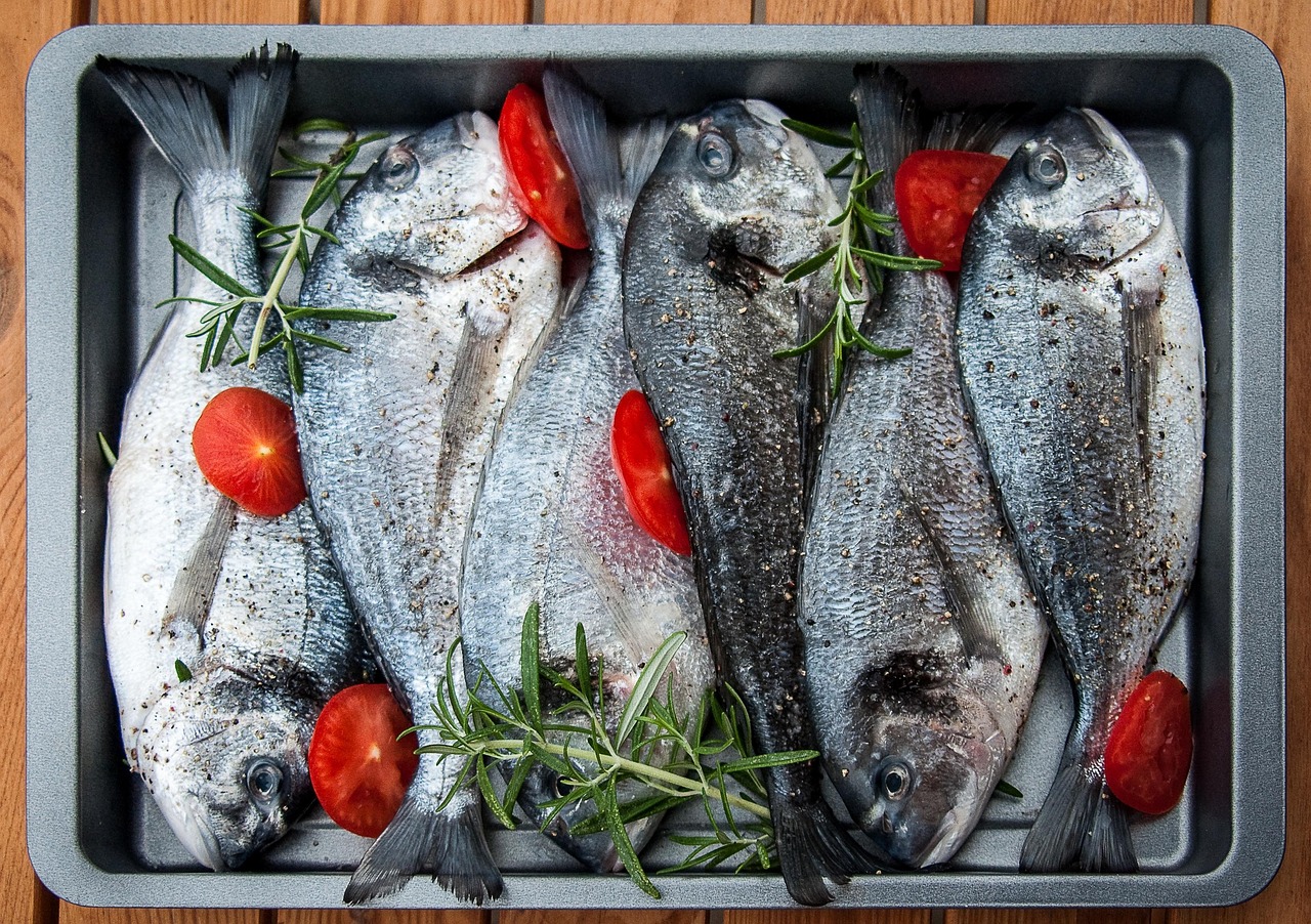 Pesce fresco su una griglia, pronto per essere cotto per preservare gli omega-3.