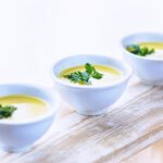 Una ciotola di zuppa calda con verdure fresche, perfetta per l'inverno e per un'alimentazione equilibrata.